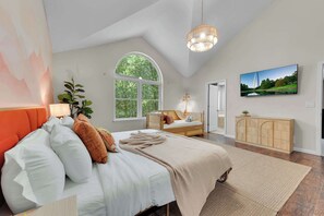 A bedroom with a large bed, a window, a television, and a cabinet. - Spacious Poconos Retreat for Families & Groups (Tobyhanna)