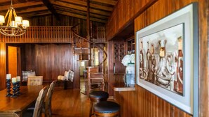 Un interno in legno con zona pranzo, una scala e un'opera d'arte incorniciata al muro.