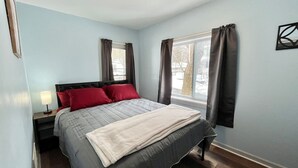 A bedroom with a bed, nightstand, and window with curtains. - 3 Queen Beds*Near BU & Hospitals*Crews Welcome (Johnson City)
