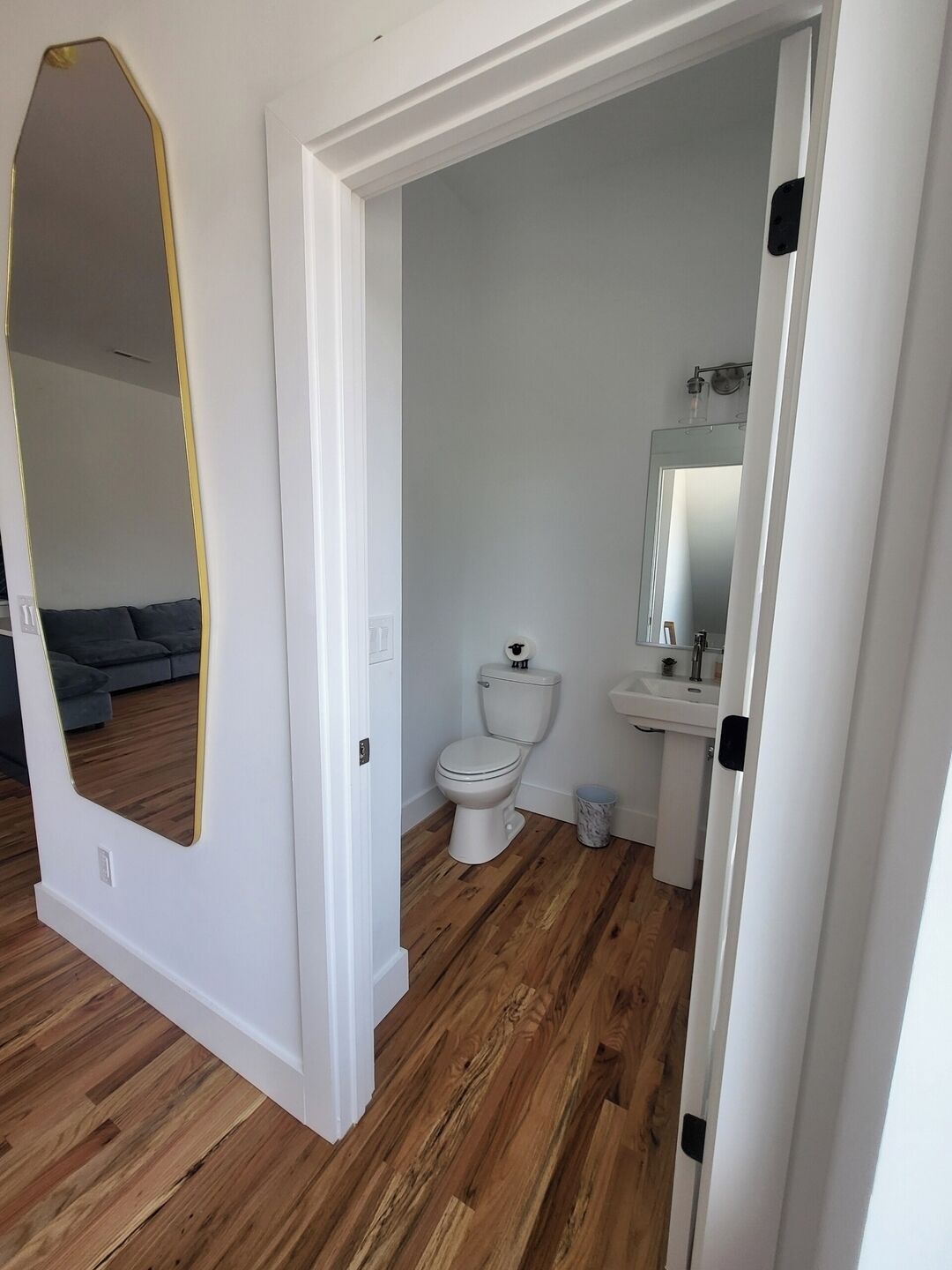 Et badeværelse med toilet, håndvask og spejl.