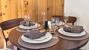 A dining table set with plates, cutlery, glasses, and folded towels.