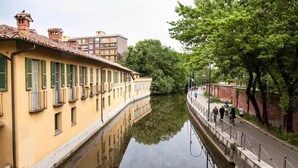 Un canal flanqueado por edificios en un lado y un sendero peatonal en el otro.