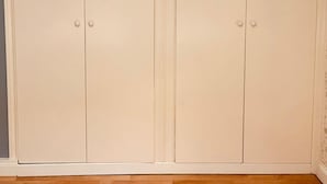 Une paire de portes doubles de couleur beige, au design simple, qui donnent probablement sur un placard ou un espace de rangement.