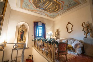 Ein prachtvoller Raum mit einer Treppe, aufwendiger Dekoration, einem Sofa und einer Statue.