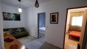 Un espace de vie compact comprenant un canapé, une petite table et un lit.