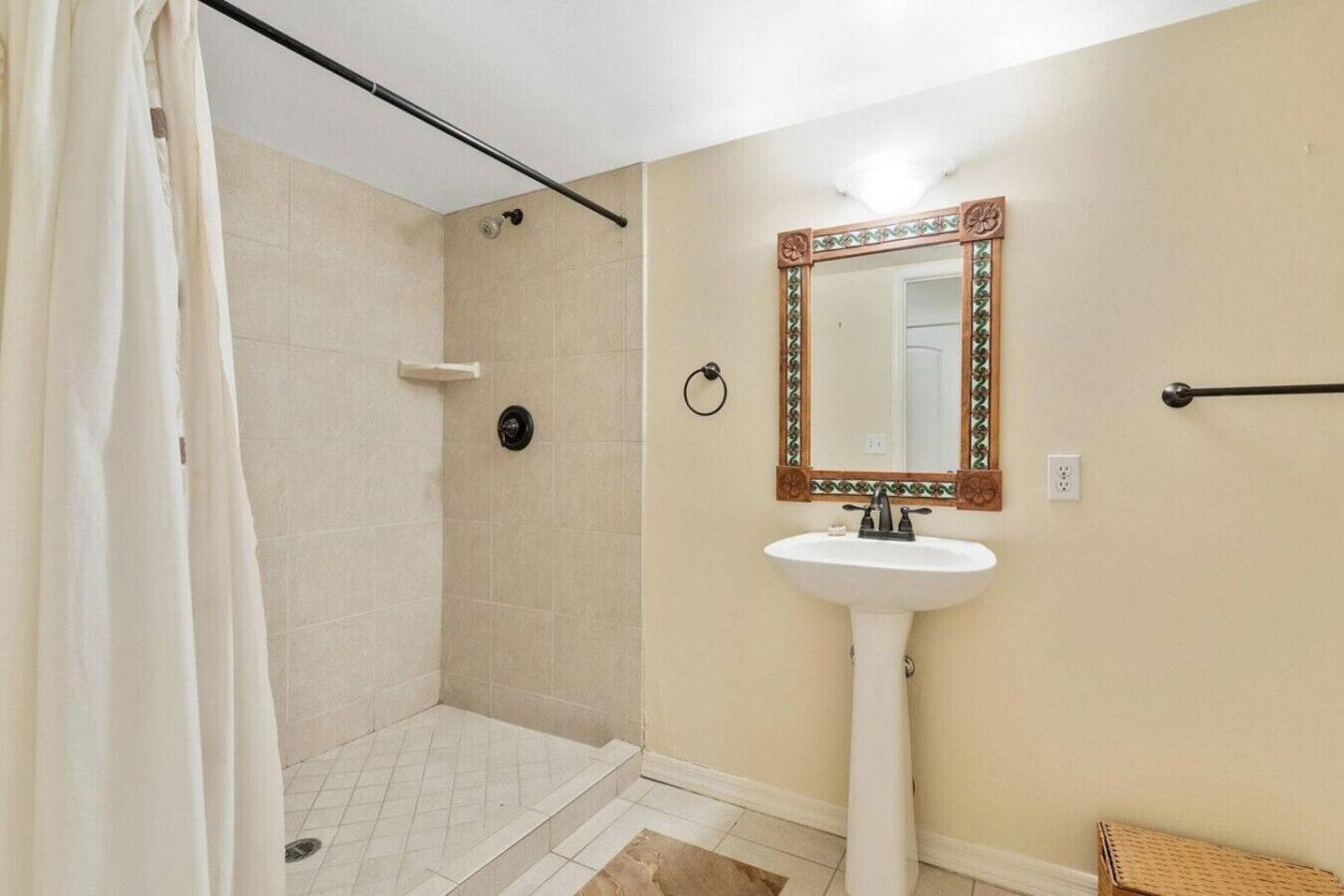 Une salle de bain avec une douche, un lavabo et un miroir.