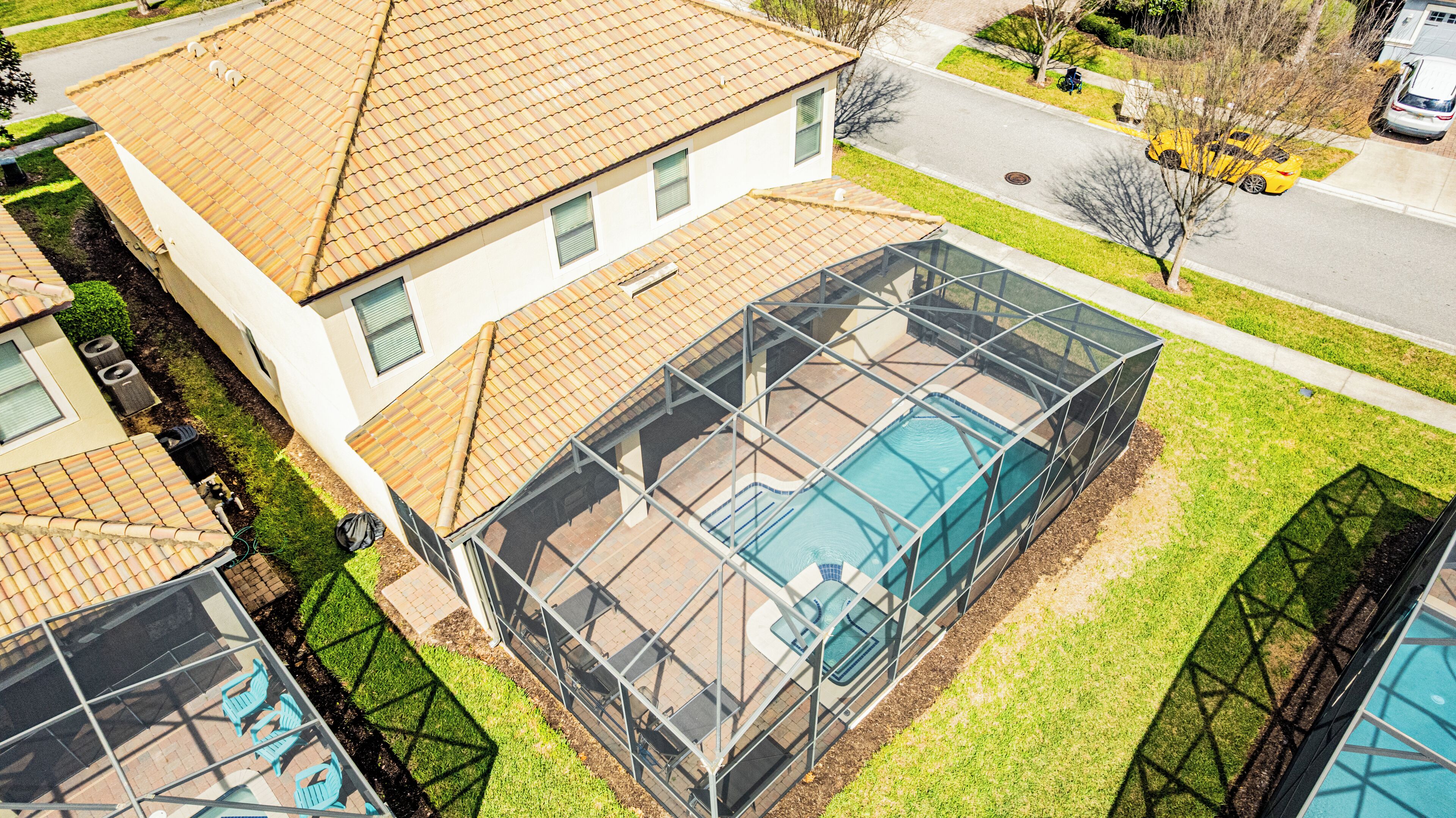Une propriété résidentielle dotée d’une piscine, d’un patio couvert et donnant sur la rue.
