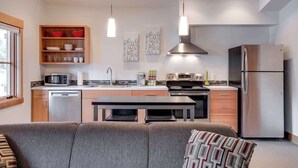 A modern kitchen with stainless steel appliances, wooden shelves, and pendant lighting. - Walk to Village-Fireplace-Festhalle Section (Leavenworth)