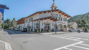 A building with a traditional architectural style, featuring a prominent tower and a balcony with statues. - Walk to Village-Fireplace-Festhalle Section (Leavenworth)