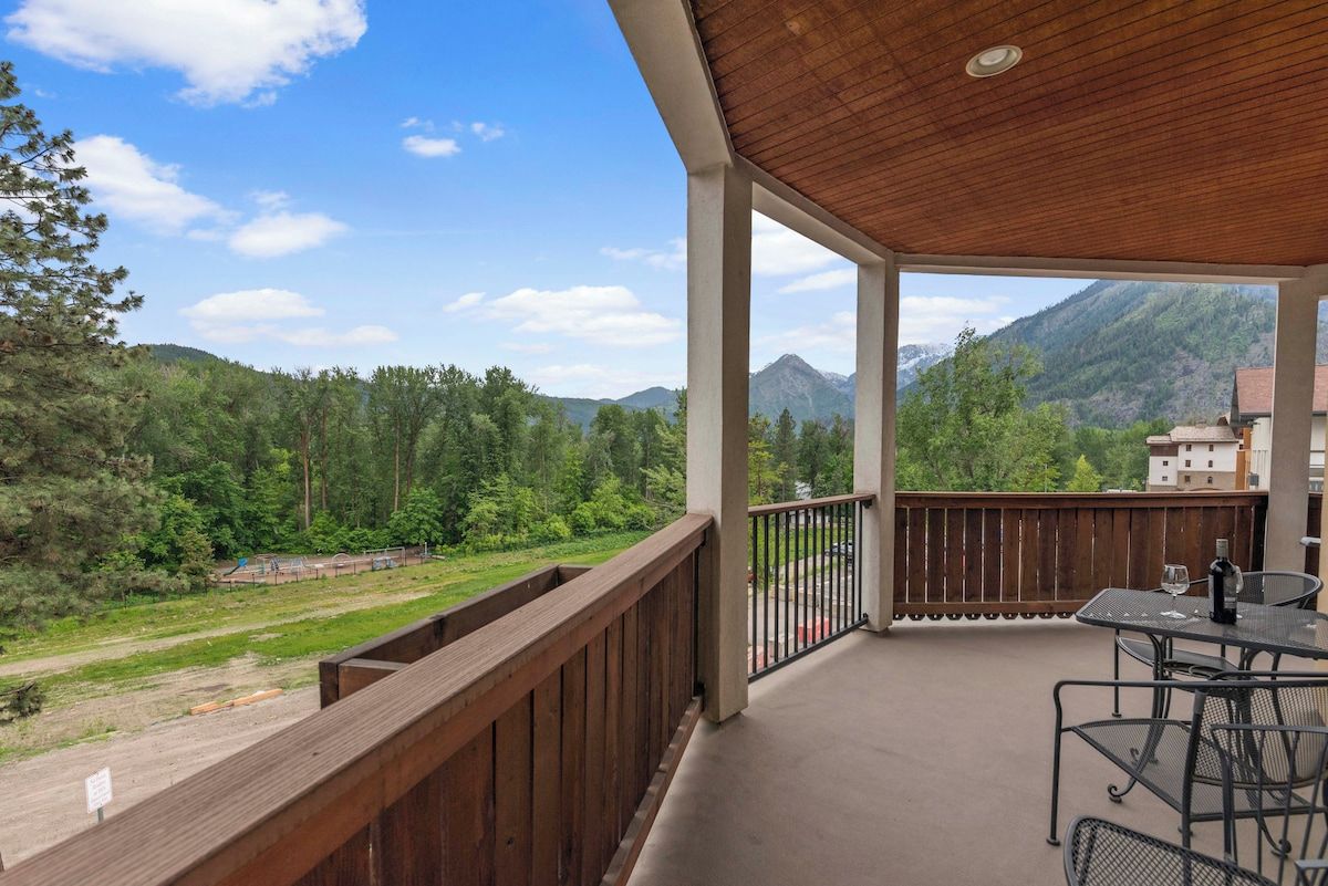 A covered balcony with a view of a mountainous landscape.
