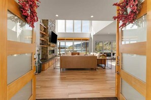 A modern interior with a central seating area, a stone accent wall, and a large window offering a view of the outdoors. - Private beach with panoramic lake views (Entiat)