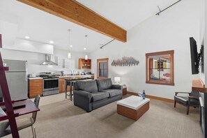Una cocina moderna con zona de comedor, un sofá gris y una mesa de centro.