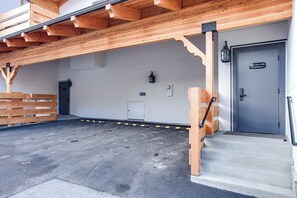 A hotel entrance with a wooden facade, a door labeled 'Hotel Street Suites Entrance,' and a small outdoor area with a bench and a wall-mounted light fixture. - As the sun dips behind the Cascade Mountains, the glow from Valhalla's gas firep (Leavenworth)