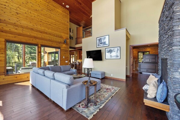 A spacious living room with a sectional sofa, a round coffee table, and a fireplace.
