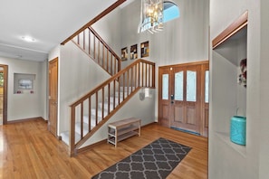 A wooden staircase with a bench at the bottom, a gray patterned rug, and a light fixture above. - As the Chelan Valley sky transitions into twilight, take your place in the steam (Manson)