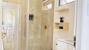 Chuveiro, secador de cabelo, toalhas de banho, shampoo