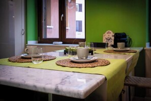 A dining area with a table set for two, featuring woven placemats, plates, and glasses. - AN EXCEPTIONAL PENTHOUSE LOCATED BETWEEN TREVI & PIAZZA DI SPAGNA - 170 SQM (Roma)