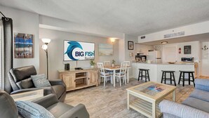 Ett vardagsrum med en soffa, ett soffbord och en tv-skärm som visar "BIG FISH Rentals".