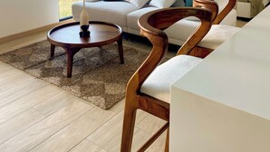 Un salon moderne avec un canapé, une table basse et une chaise en bois au design original.