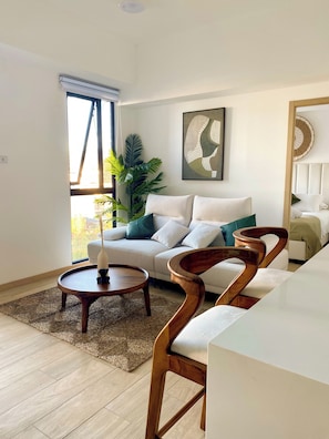 Una sala de estar moderna con un sofá, una mesa de centro y una silla de madera original.