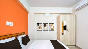 A hotel room with a bed, a wardrobe, and three framed artworks on the wall. - Classic Royal Rooms (Bengaluru)
