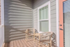 A porch with two wicker chairs and a small table, a door with a window, and a white railing. - Landing | Chic 1BD, Clubhouse, Gym (San Marcos)