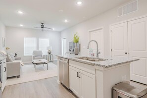 A modern kitchen with white cabinetry, granite countertops, and a built-in sink. - Landing | Modern 1BD, Gym, Pool (San Marcos)