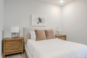 A bedroom with a bed, two nightstands, and a wall-mounted artwork. - Landing | Spectacular 2BD, Clubhouse, Gym (San Marcos)