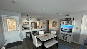 A modern kitchen with a central island, bar area, and seating for dining. -  3Bed2Bath Waterfront Condo - Alluring Main Channel and Pool Views! (Osage Beach)