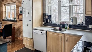 A modern kitchen with a dishwasher, a sink, and a coffee maker. There is a window with a view of trees outside. - Lovely home in Eskebjerg with WiFi (Eskebjerg)
