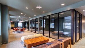 A modern office space with glass partitions, leather seating, and a wooden table. - Landing | Stunning 1BD in Downtown Hartford (Hartford)