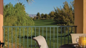 A balcony with a view of a golf course, a table with a pitcher and glasses, and a chair. - Relaxing Marriott Shadow Ridge 2-bedroom resort in peaceful Palm Desert (Palm Desert)