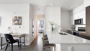 Una cocina moderna con una isla central, electrodomésticos de acero inoxidable y un diseño minimalista.