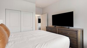 A bedroom with a bed, a dresser, a television, and a closet. - Landing | Modern 2BD, Clubhouse, Gym (Marysville)