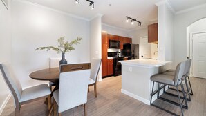 Cocina moderna con armarios de madera, un microondas y un refrigerador.