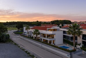 A modern residential building with a swimming pool, surrounded by greenery and a curved road. - Villa Fasana 3 - luxury apartment with sea view and private pool for 6 persons. (Fažana)