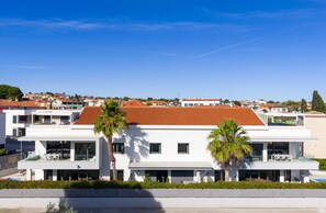 Un bâtiment moderne à deux étages, doté d’un toit plat, de grandes fenêtres et d’une piscine.