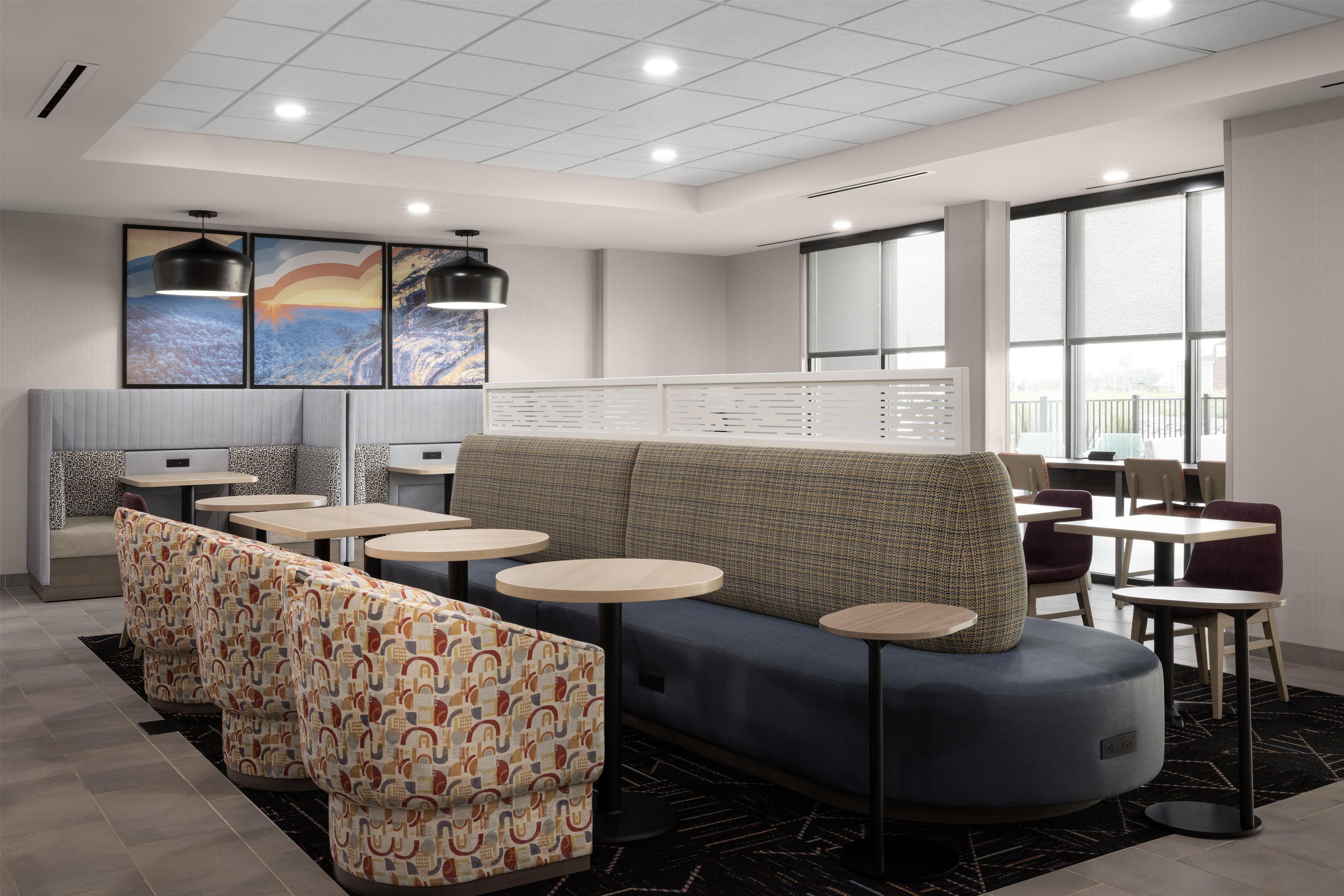 A modern interior with seating areas, tables, and artwork on the walls.
