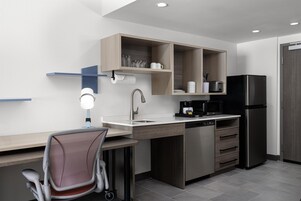 Una cocina moderna con lavavajillas integrado, cafetera y microondas.