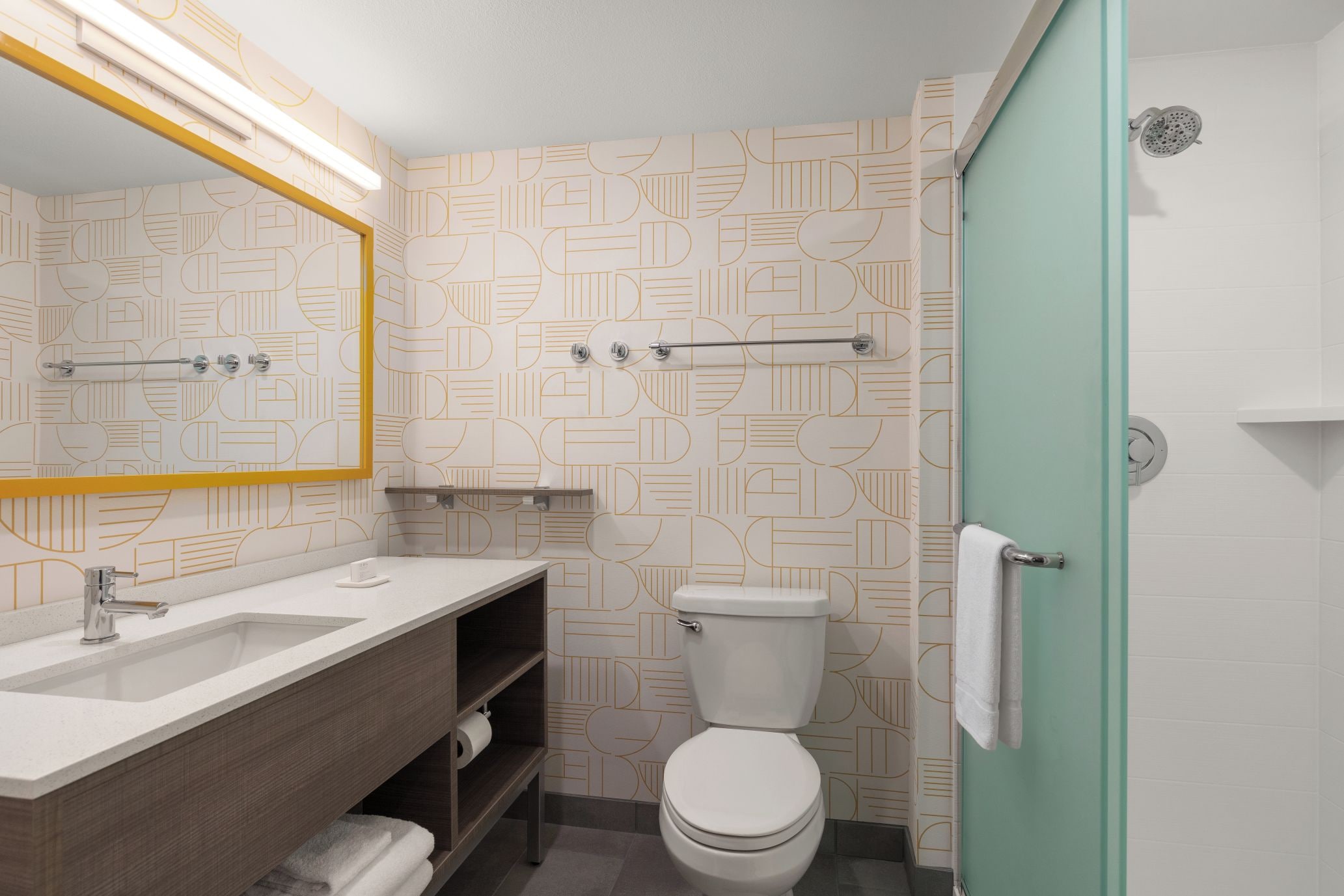 Un baño con inodoro, lavamanos y espejo.
