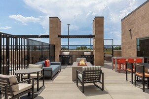 Un patio al aire libre con un brasero, asientos y vistas al cielo.