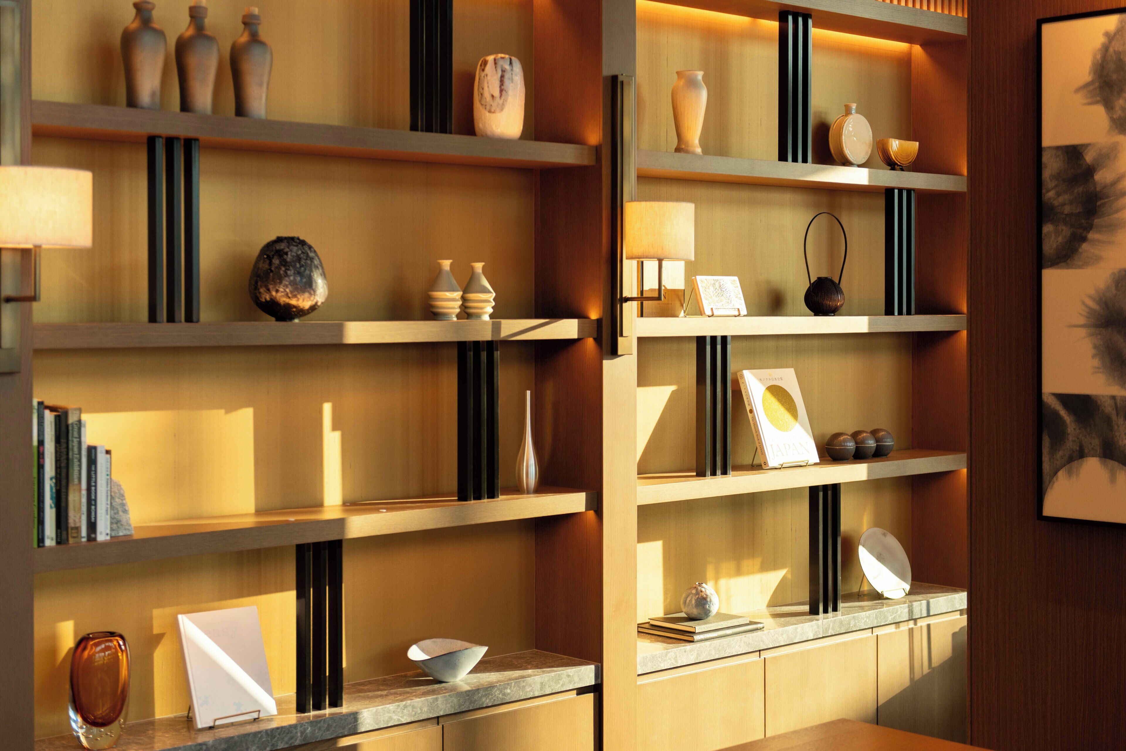 Een netjes ingericht interieur met planken waarop diverse decoratieve objecten, een ingelijst kunstwerk en een boek met de titel 'JAPAN' staan.