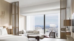 A modern hotel room with a large bed, a sofa, a small table, and a city view through floor-to-ceiling windows. - Conrad Nagoya (Nagoya)