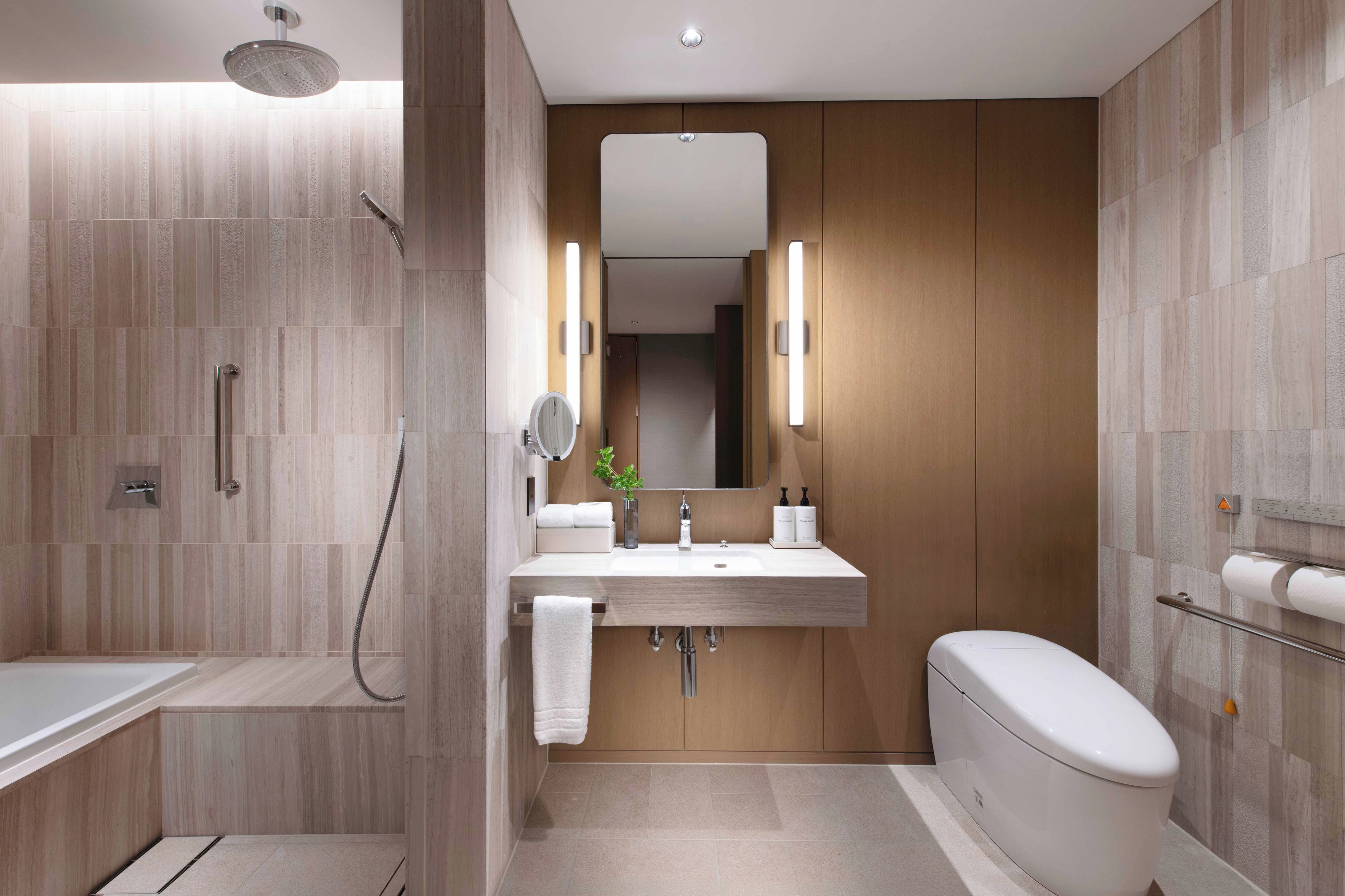 A modern bathroom with a shower, sink, and toilet.