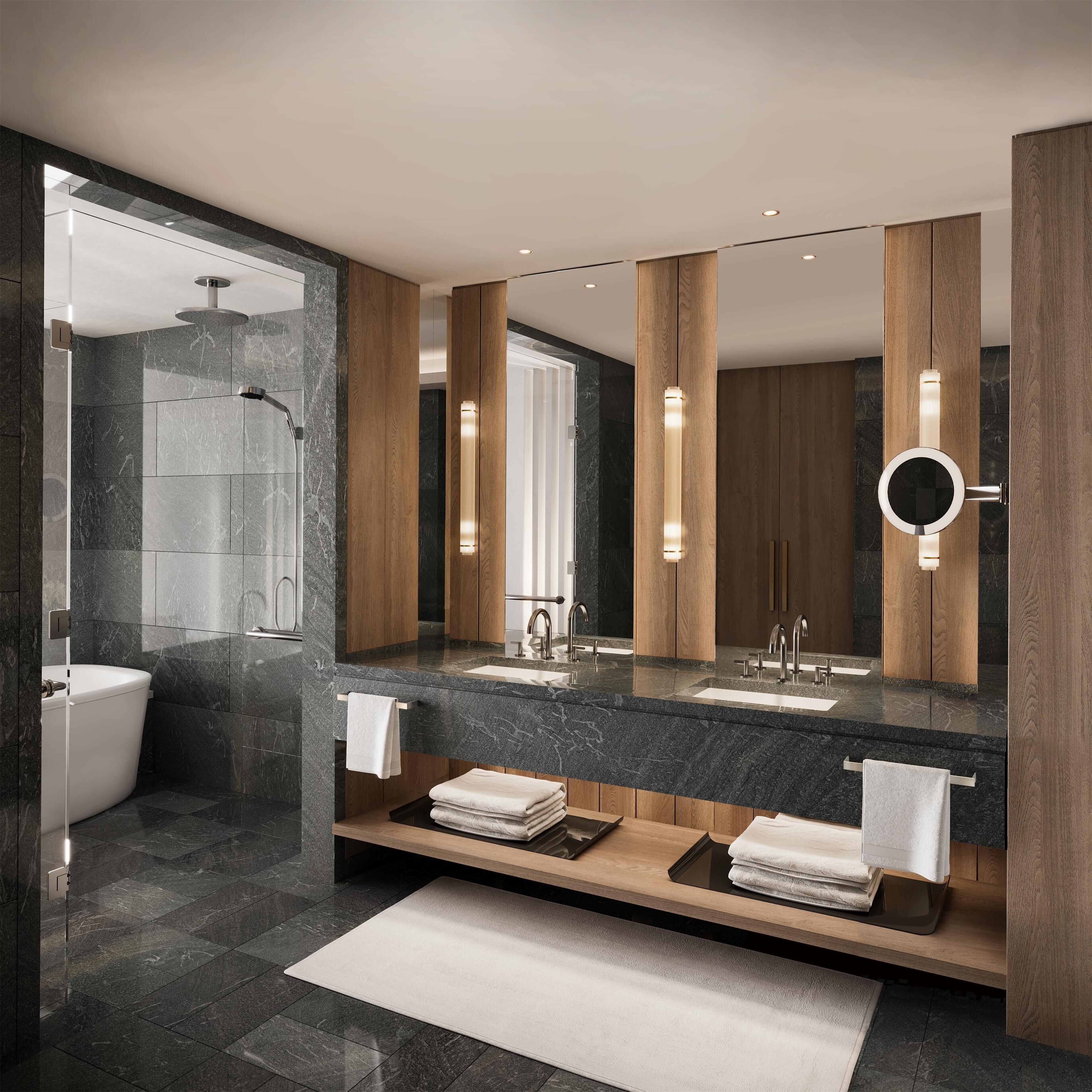 A modern bathroom with a large mirror, two sinks, a shower, and wooden accents.