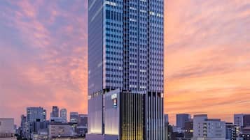 Un edificio de gran altura con fachada de vidrio moderna y el nombre 'CONRAD' en la parte superior.