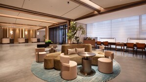 A spacious lobby with a central seating area, a reception desk, and a large window providing natural light. - Hilton Garden Inn Chengdu Huaxi Wuhou Shrine (Nanchong)