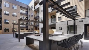 Un espace cuisine extérieur moderne, doté d’un bar, de sièges et d’un barbecue.