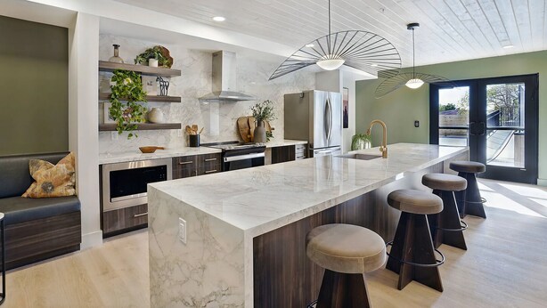 A modern kitchen with a marble countertop, stainless steel appliances, and a central island with stools. - Landing | Spectacular 1BD, Gym, Pool (Salt Lake City)