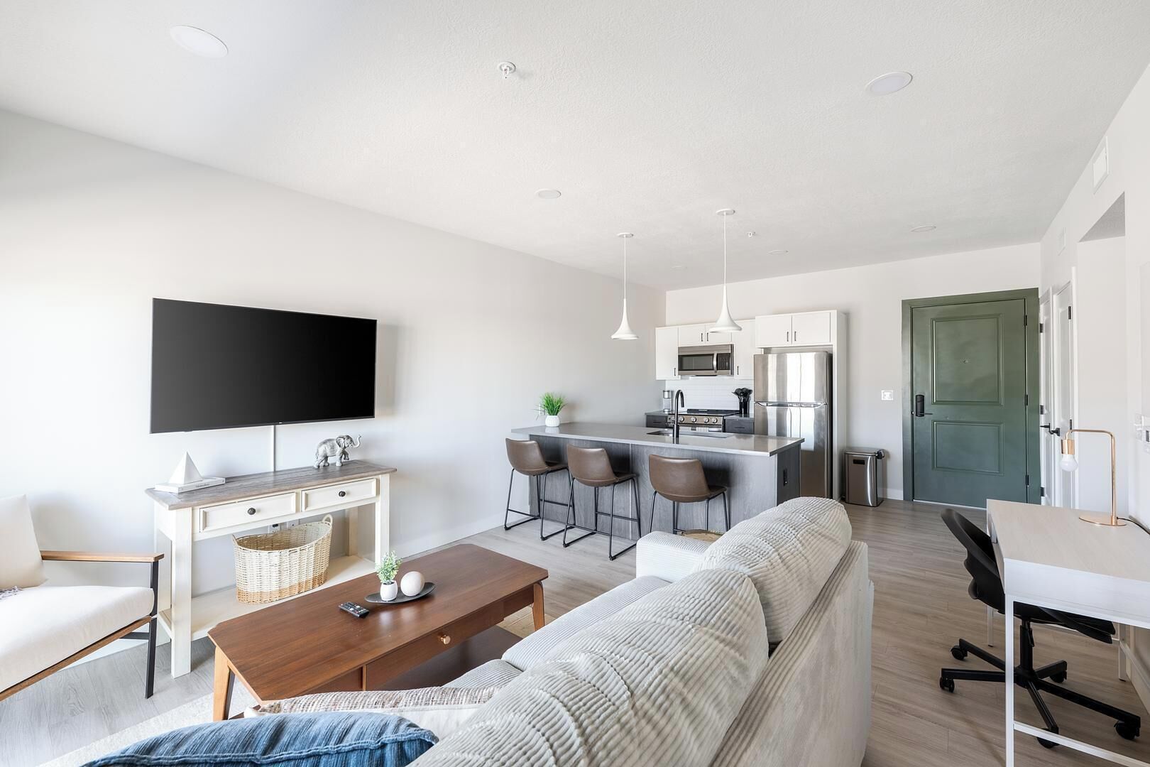A modern apartment with a living room, kitchen, and dining area.